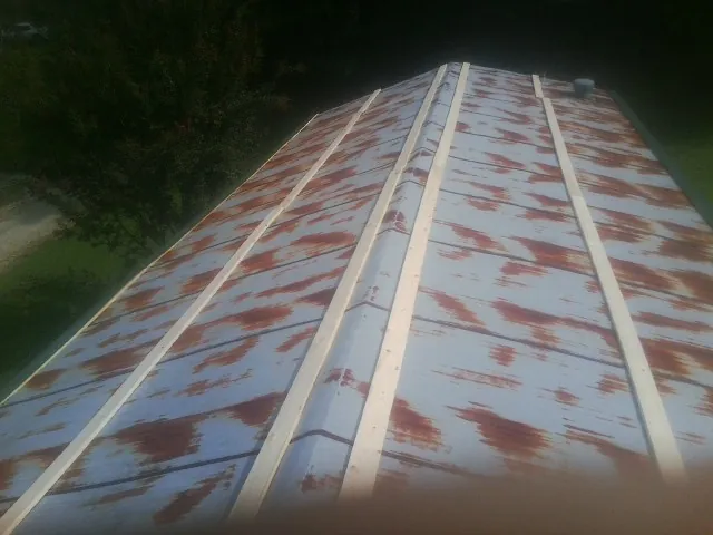 Rusted metal roof panels with new wood purlins before replacement — Storm Damage Roof Repair in Hicksville by Roofing Brothers
